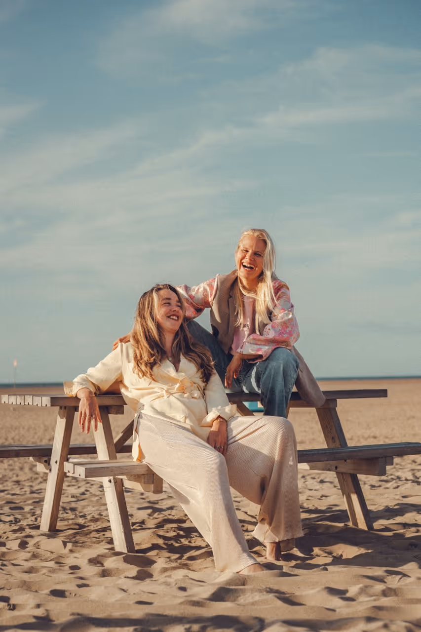 Founders We Do Better zittend op een houten picknicktafel op het strand