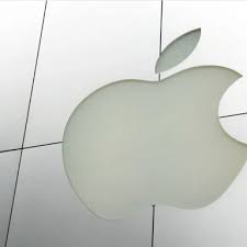 The Apple logo displayed on a tiled wall, shown as a large, smooth, metallic emblem shaped like a bitten apple with a leaf on top.