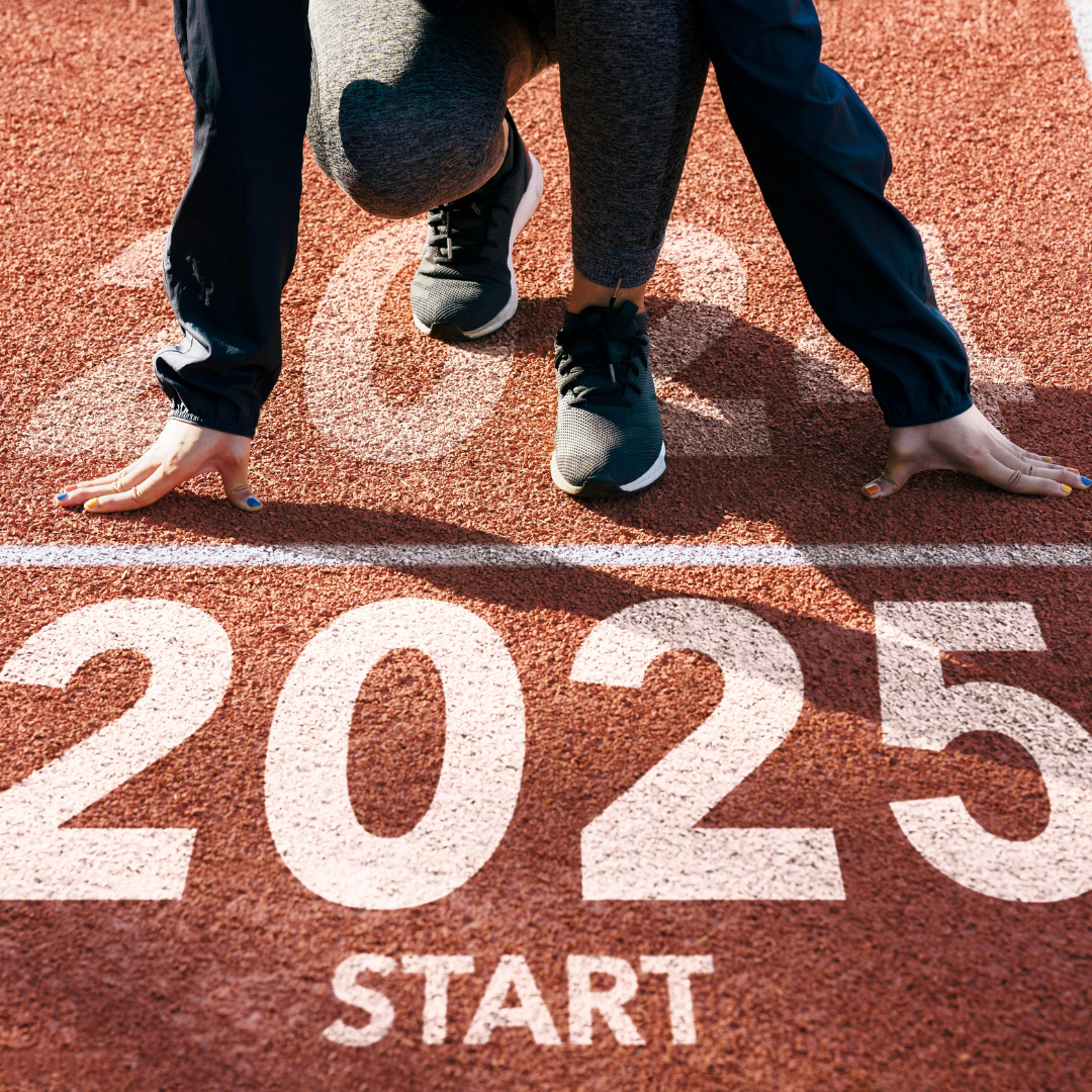 Athlete in a starting position on a track with “2025” and “START” painted on the ground.