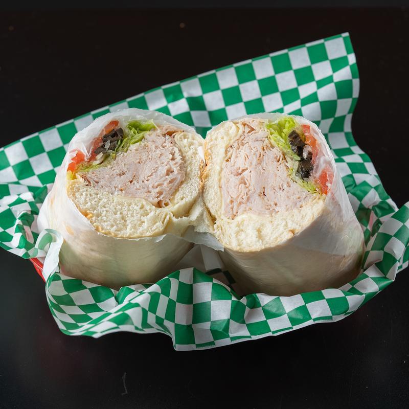 Turkey sub cut in half, on top of a tray.