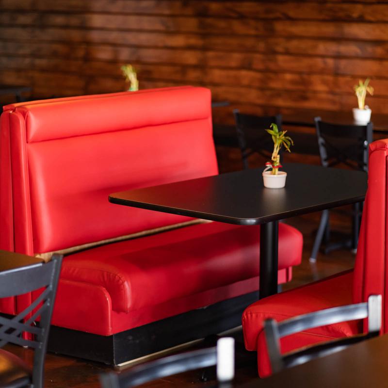 A red restaurant booth with a dark table