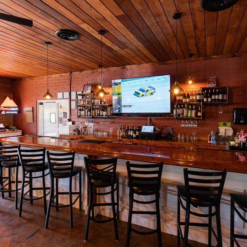 Restaurant bar with various stools arranged in a line.