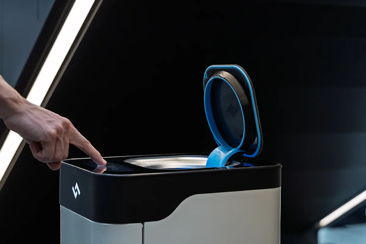 Finger pressing touch sensor on instarinse cup cleaning machine to activate reusable cup cleaning system.