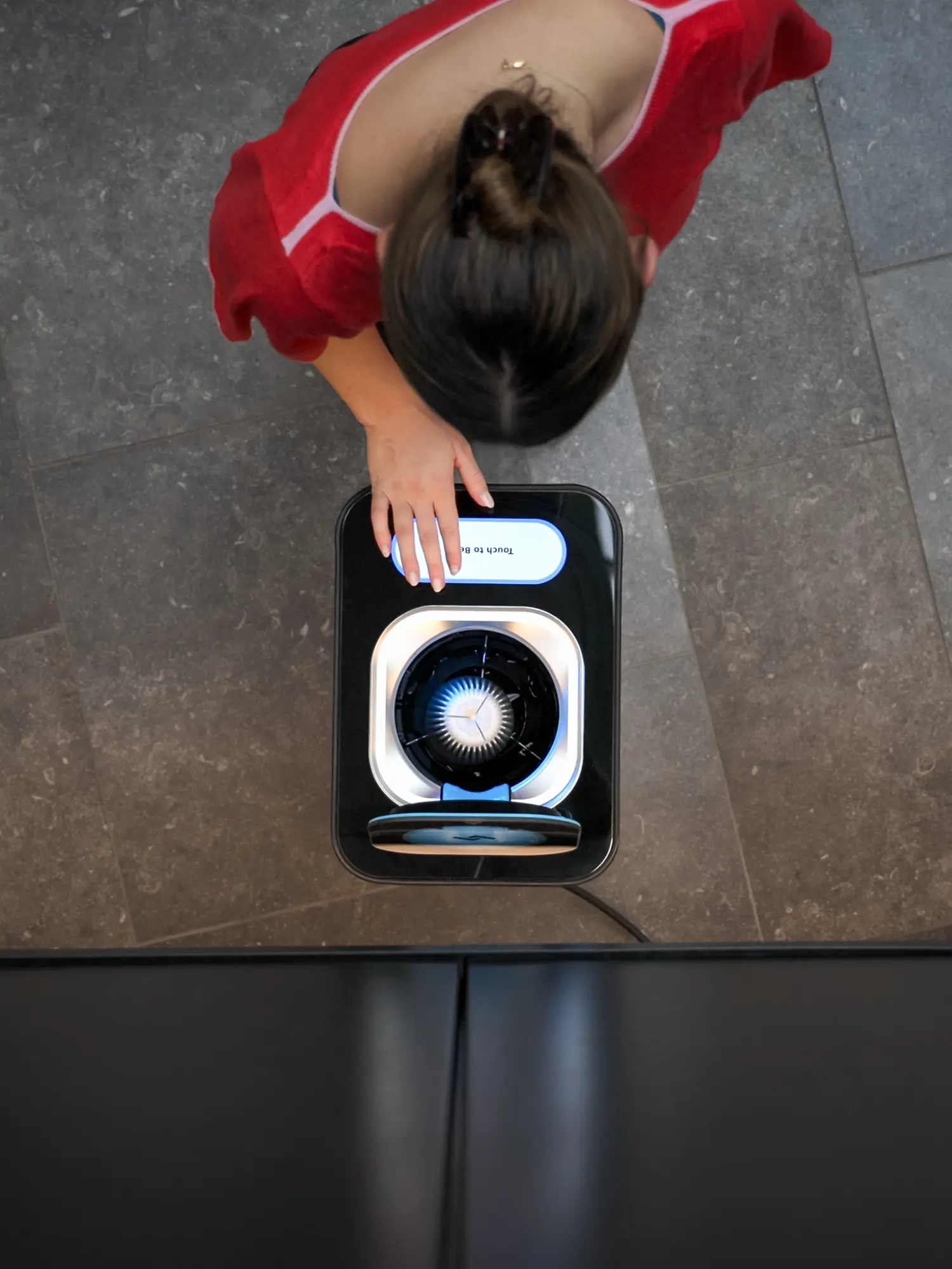 A top down view of a women using an instarinse machine.