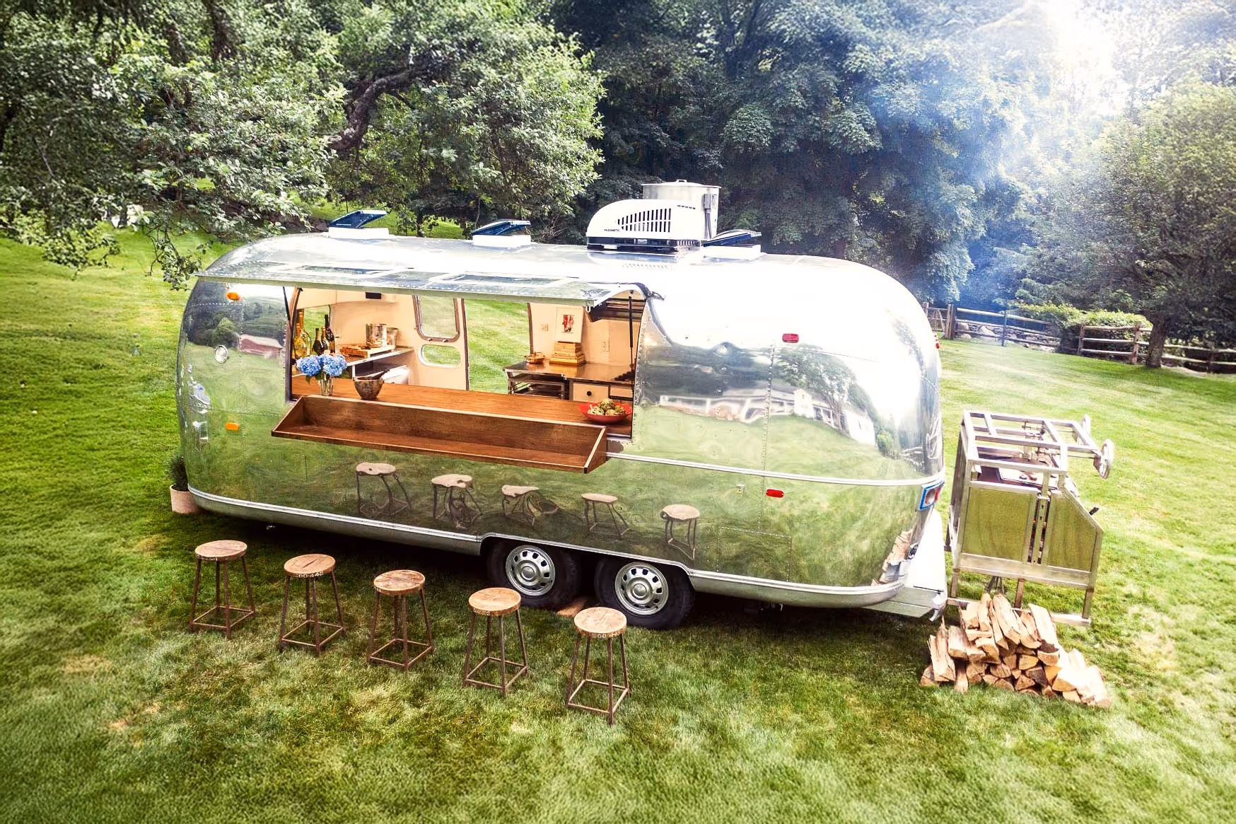 The Yann Nury airstream in backyard country side with open bar and stools alongside