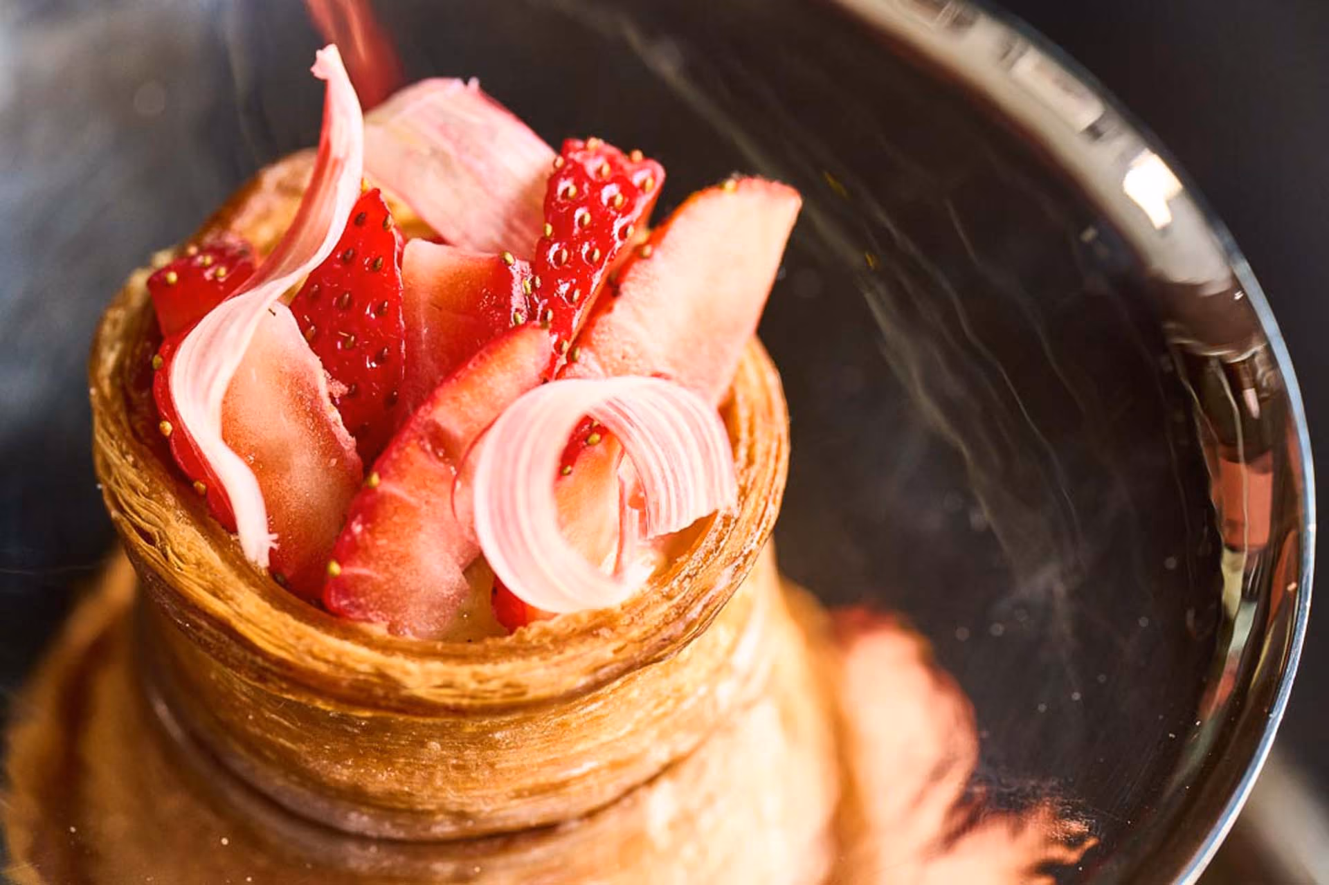 Overhead close-up of a pastry shell filled with strawberries and rhubarb ribbons