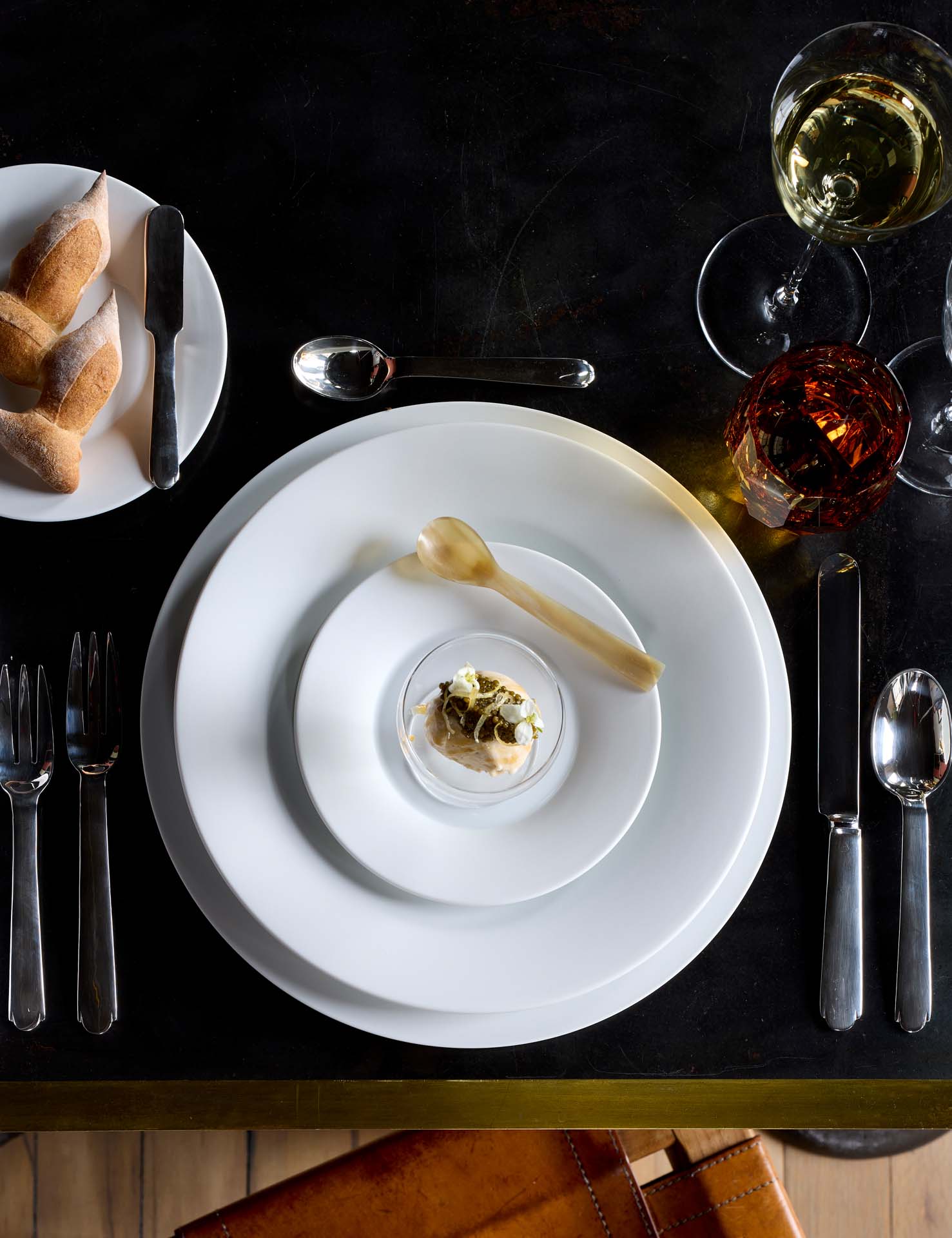 Place setting on black table for private dinner by chef Yann Nury