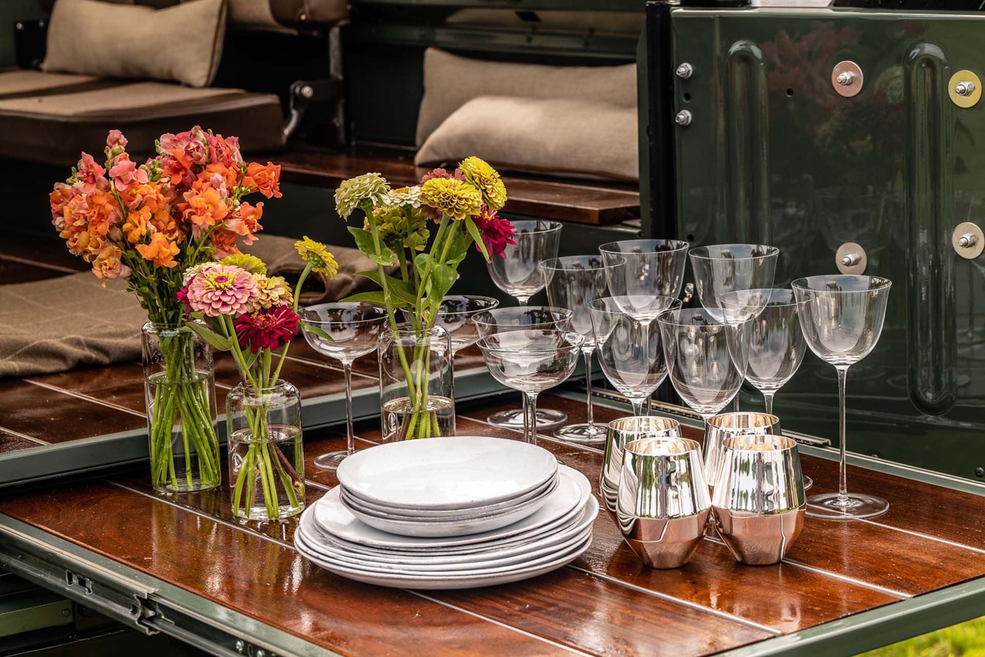 Plates, wine, glasses, metal cups and flower vase on table for luxury event
