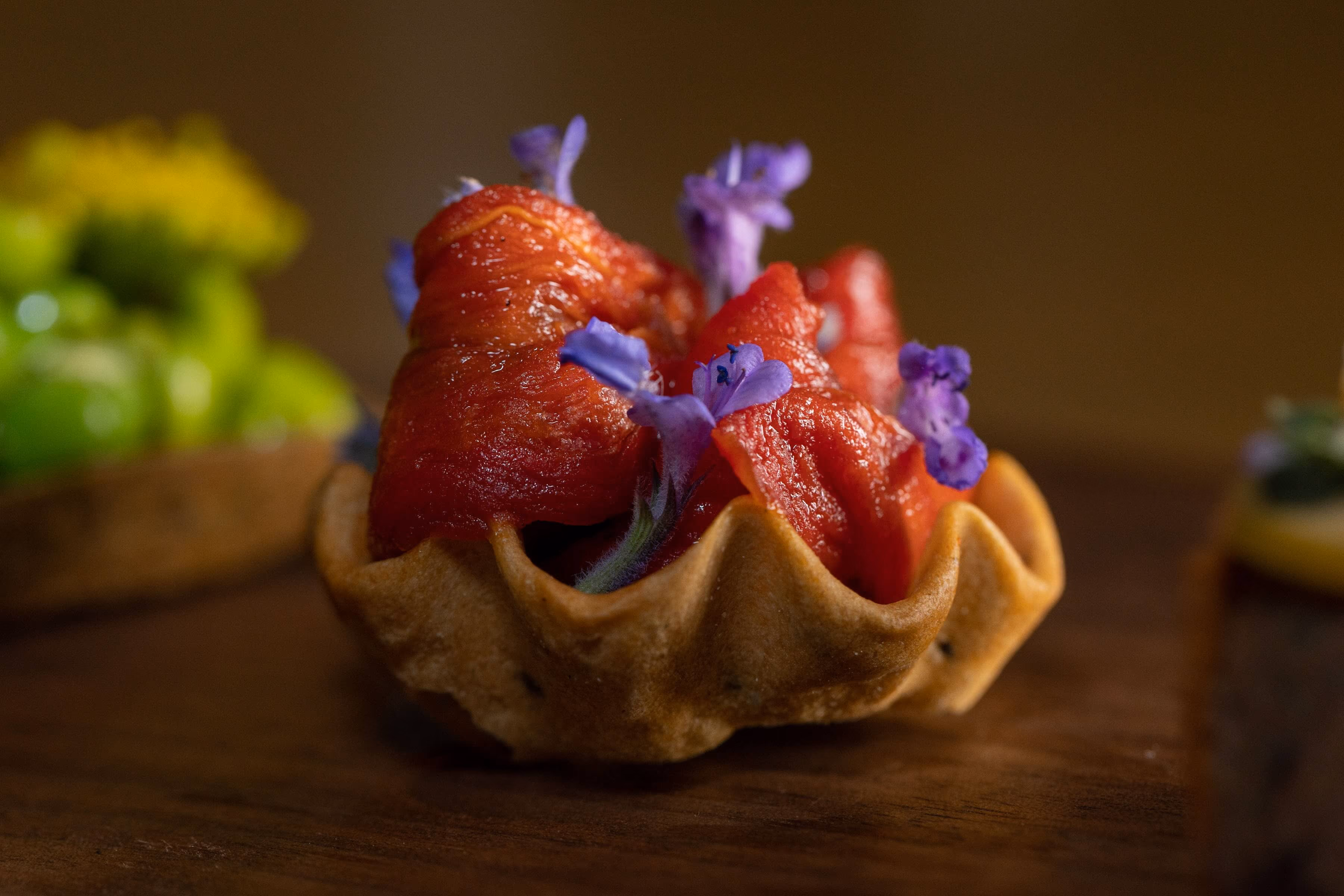 Tomato-filled pastry tart garnished with purple flowers
