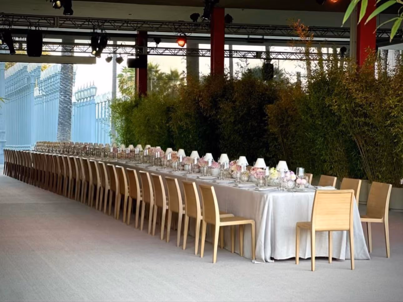 Long outdoor banquet table set for a formal dinner beside a museum building
