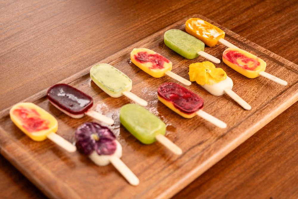 Ten assorted popsicles arranged on a wooden board