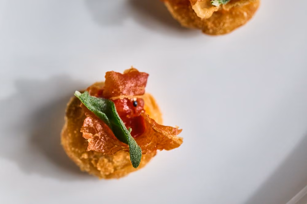 Crispy fried bite topped with prosciutto and sage