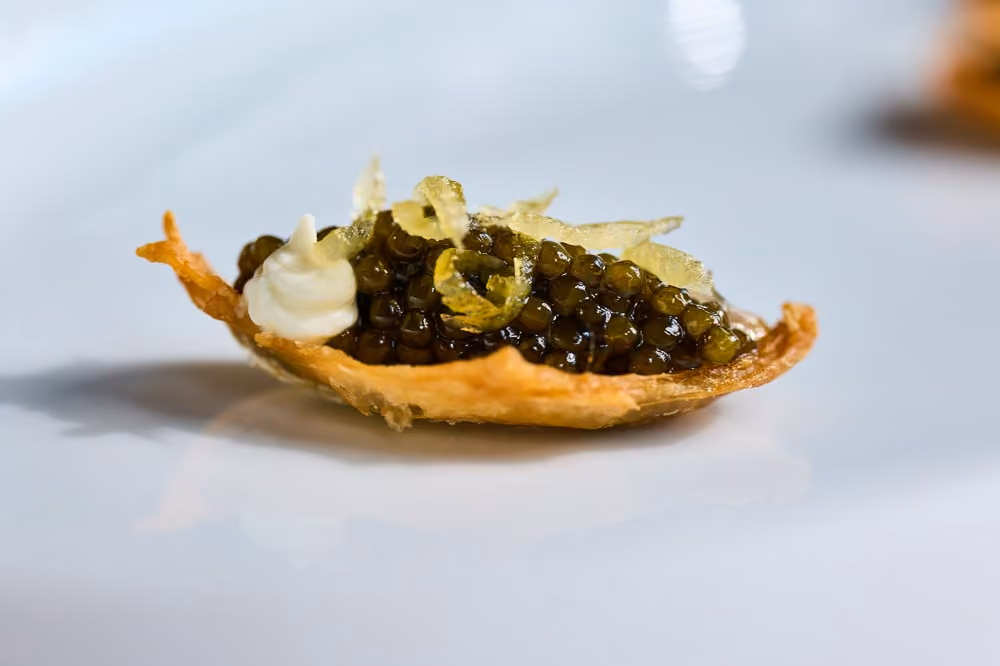 Crispy tuile canapé topped with caviar, crème fraîche, and citrus zest
