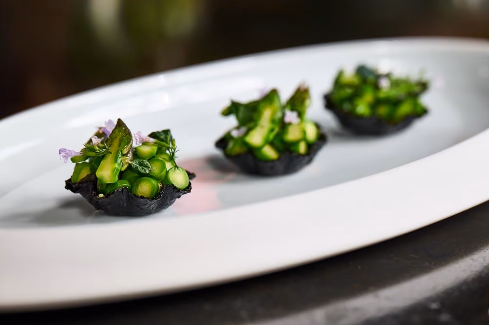 Black tart shells filled with asparagus and green beans