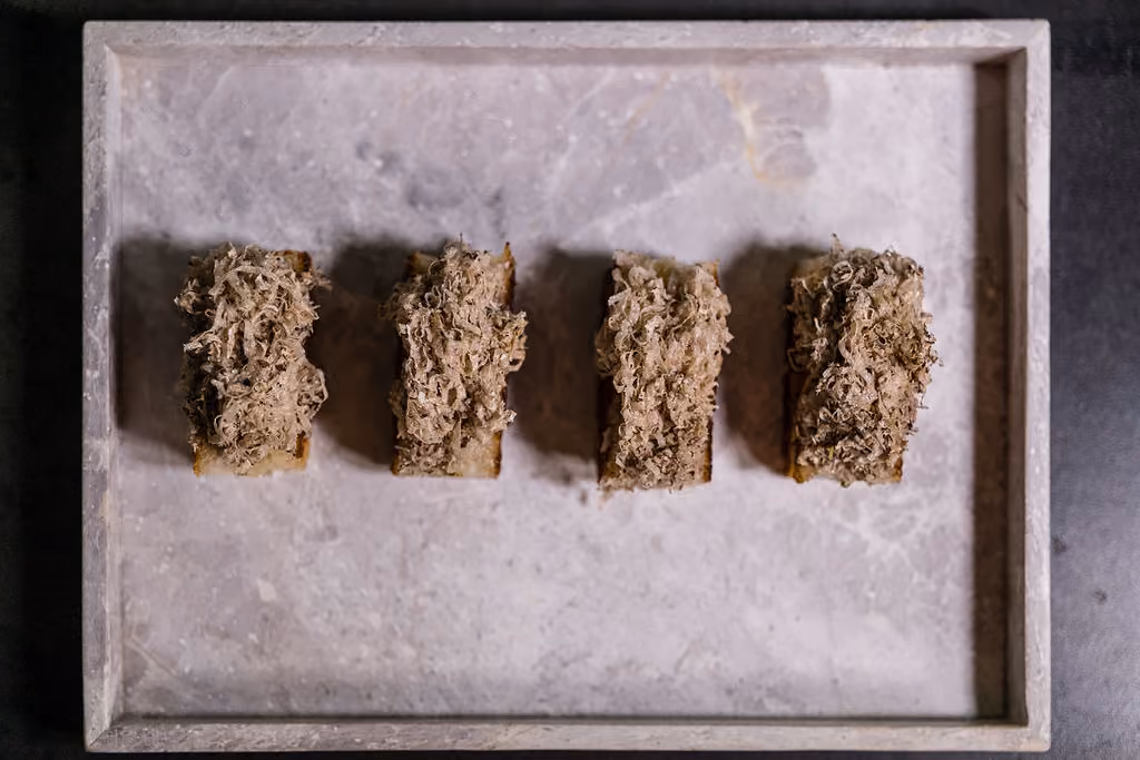 Overhead row of toasts topped with shaved truffle