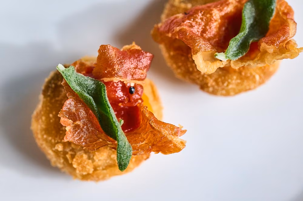 Pair of crispy prosciutto cups filled with tomato jam and sage