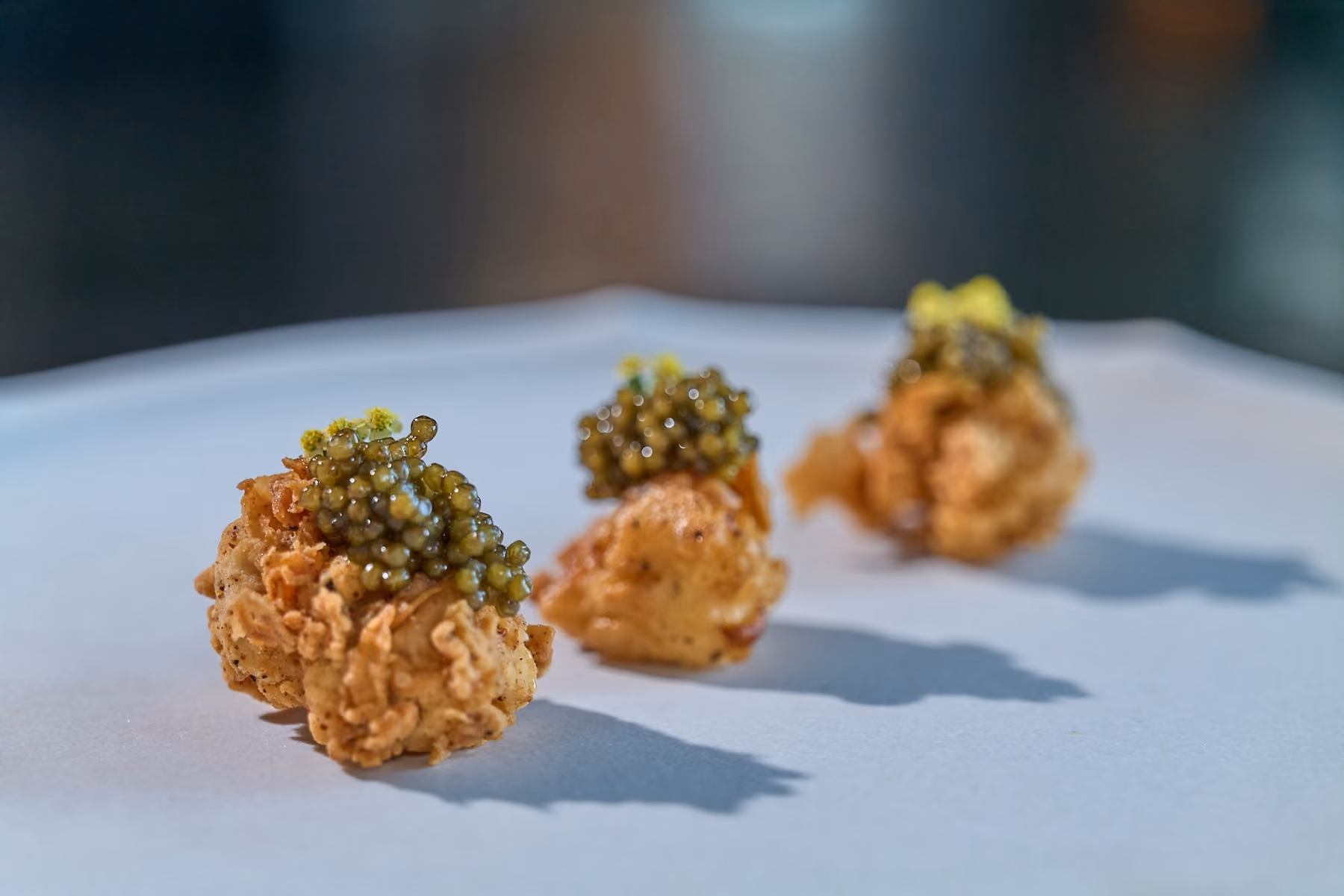 Row of crispy fried bites topped with caviar