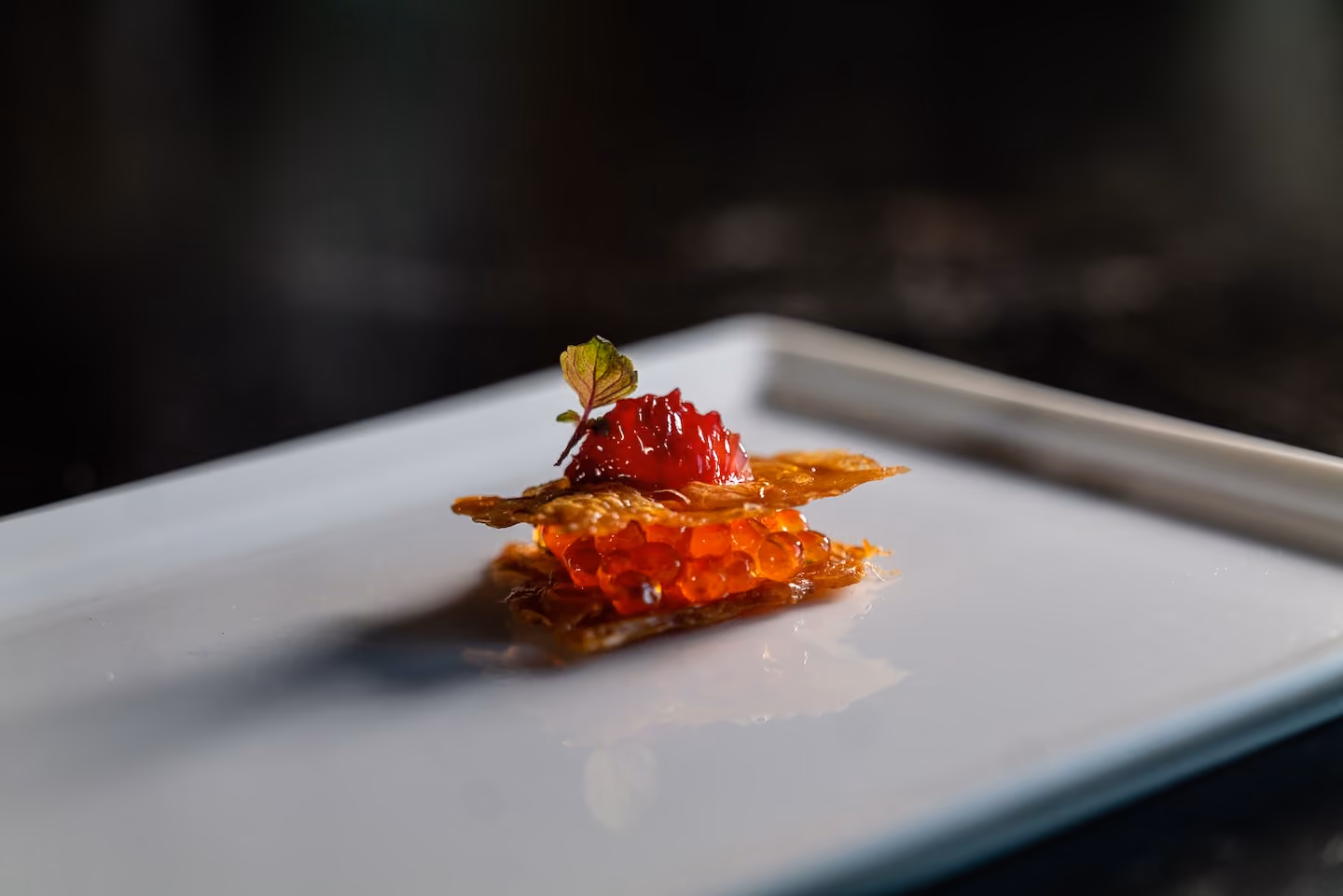 Crispy tuile canapé topped with salmon roe and a red fruit jam