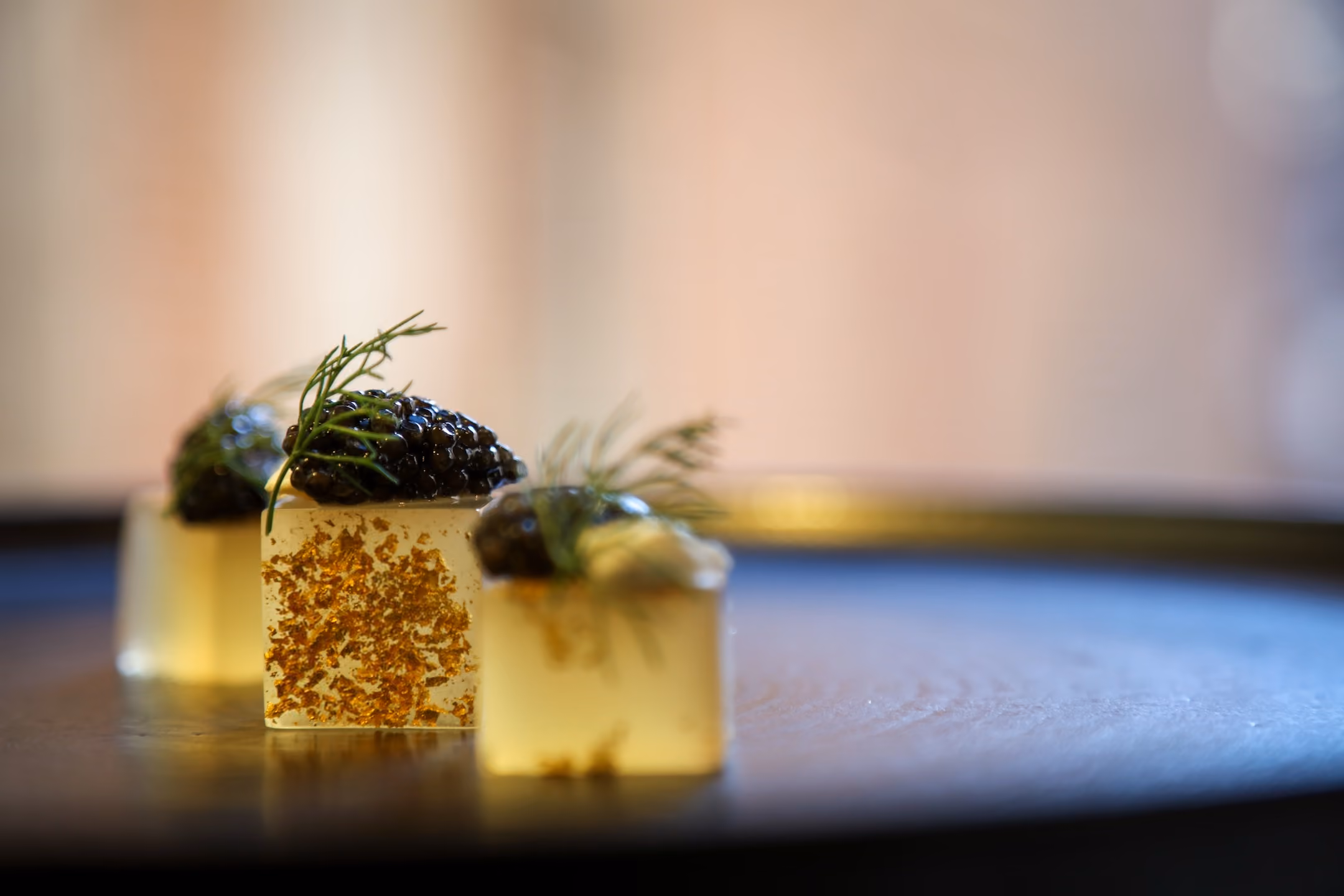 Gelée cubes finished with gold leaf and topped with caviar and dill