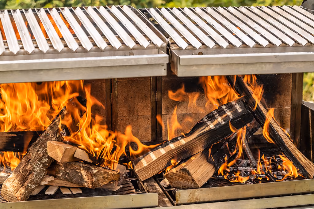 Close-up of a wood fire burning beneath a grill grate