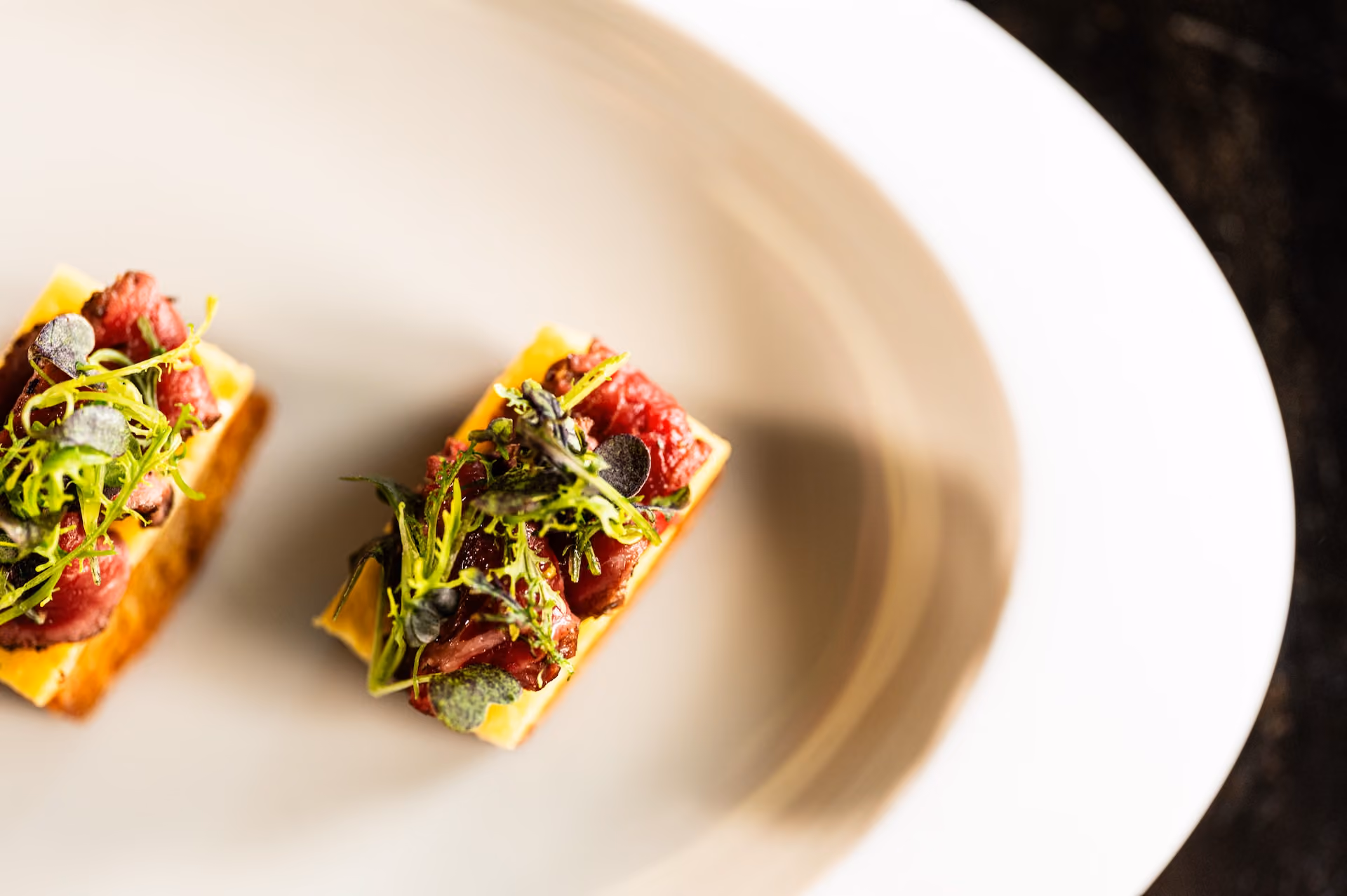 Beef tartare canapés on toasted brioche with frisée greens