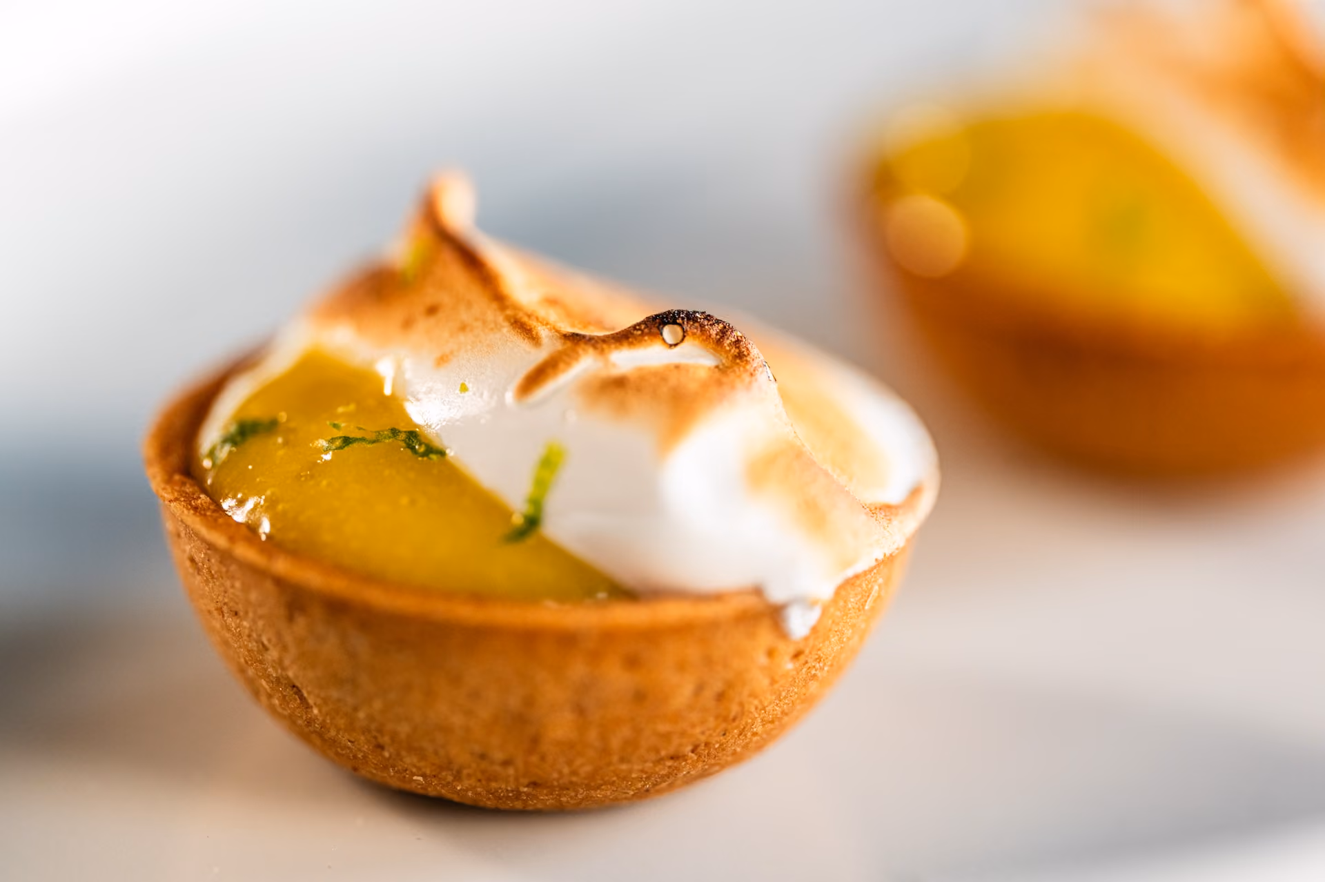 Mini lemon meringue tart with a torched meringue peak