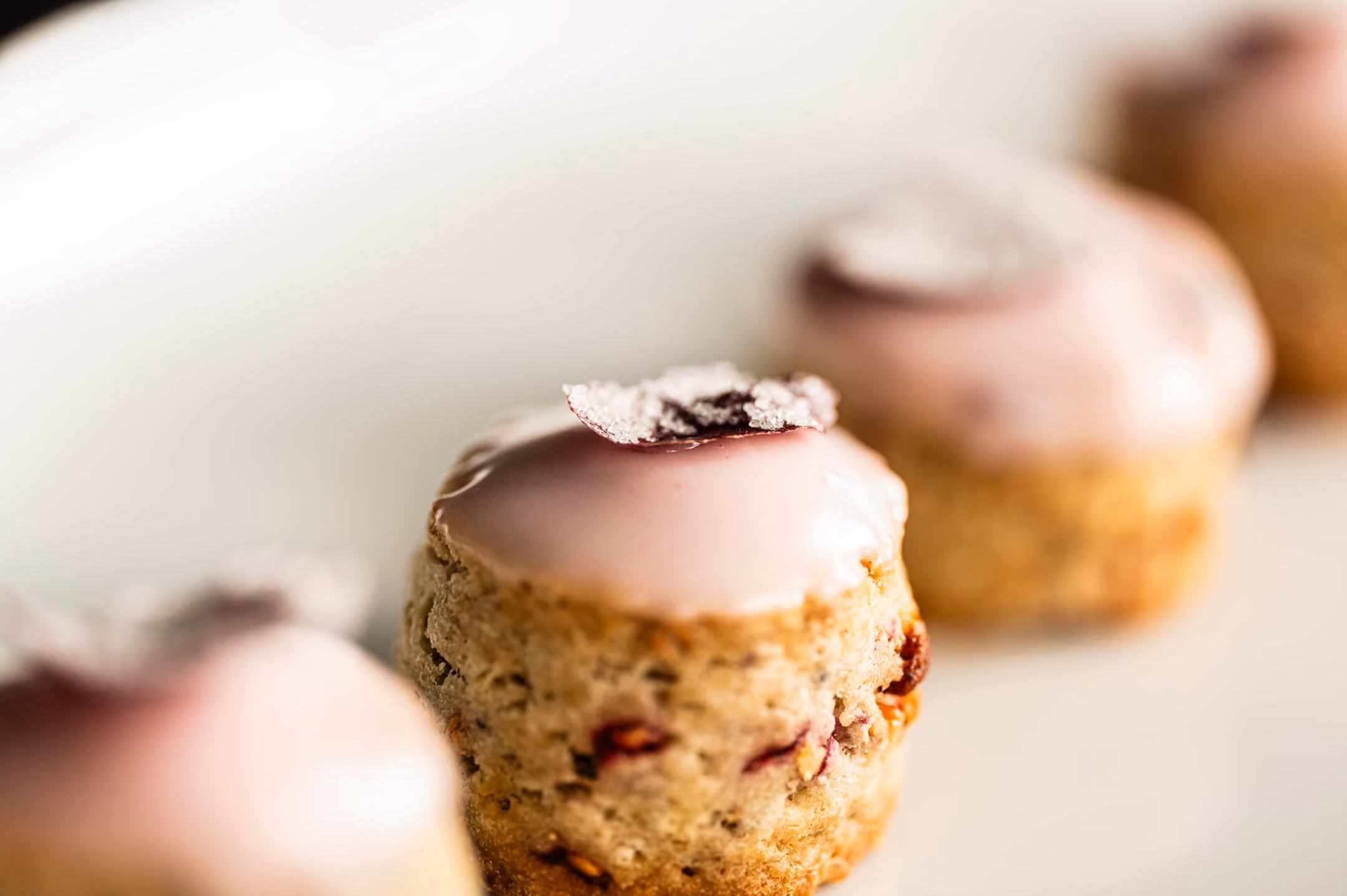 Berry-studded petits fours with pink glaze and candied fruit garnish