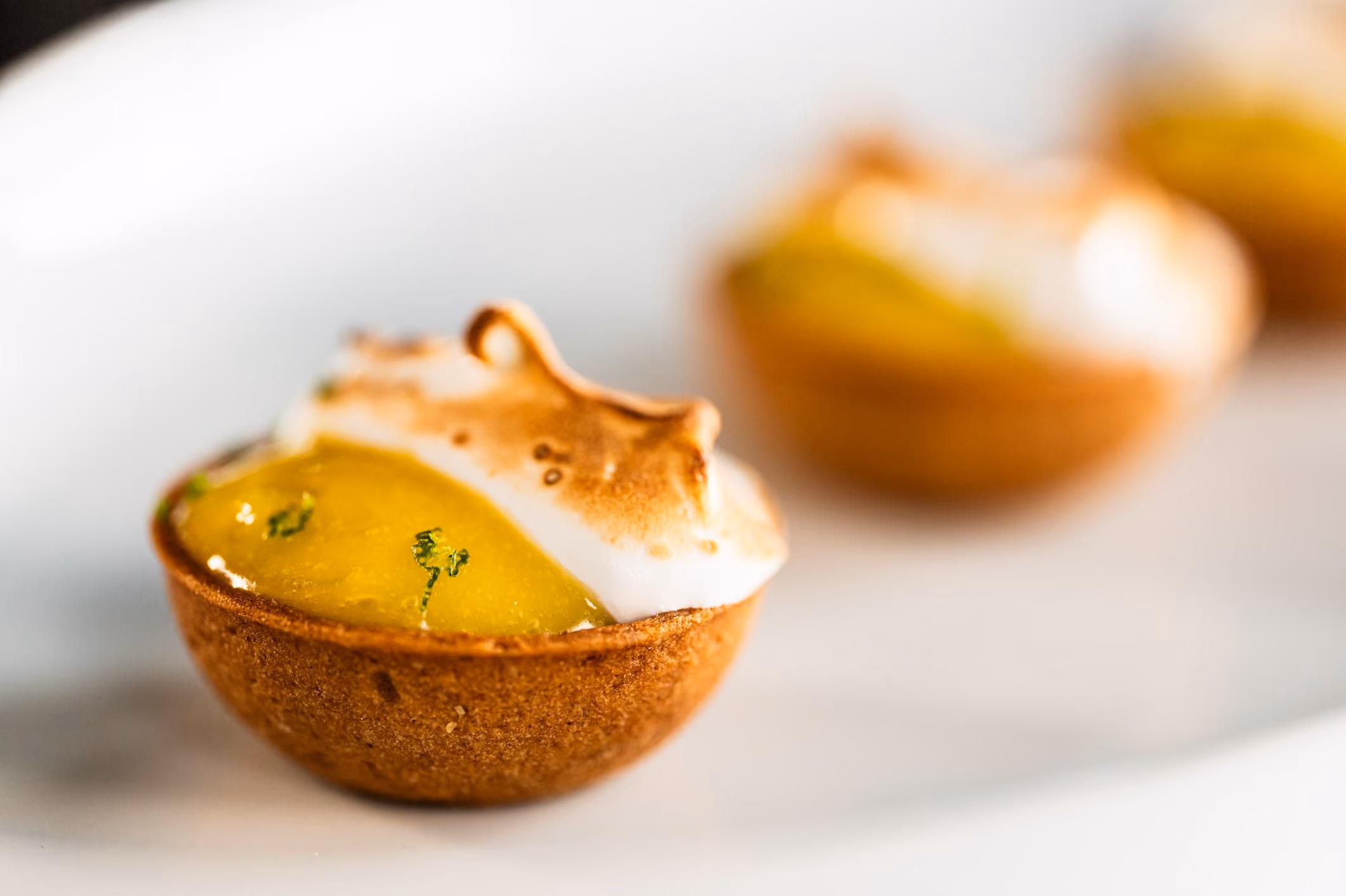 Mini lemon meringue tartlets with torched, peaked meringue tops