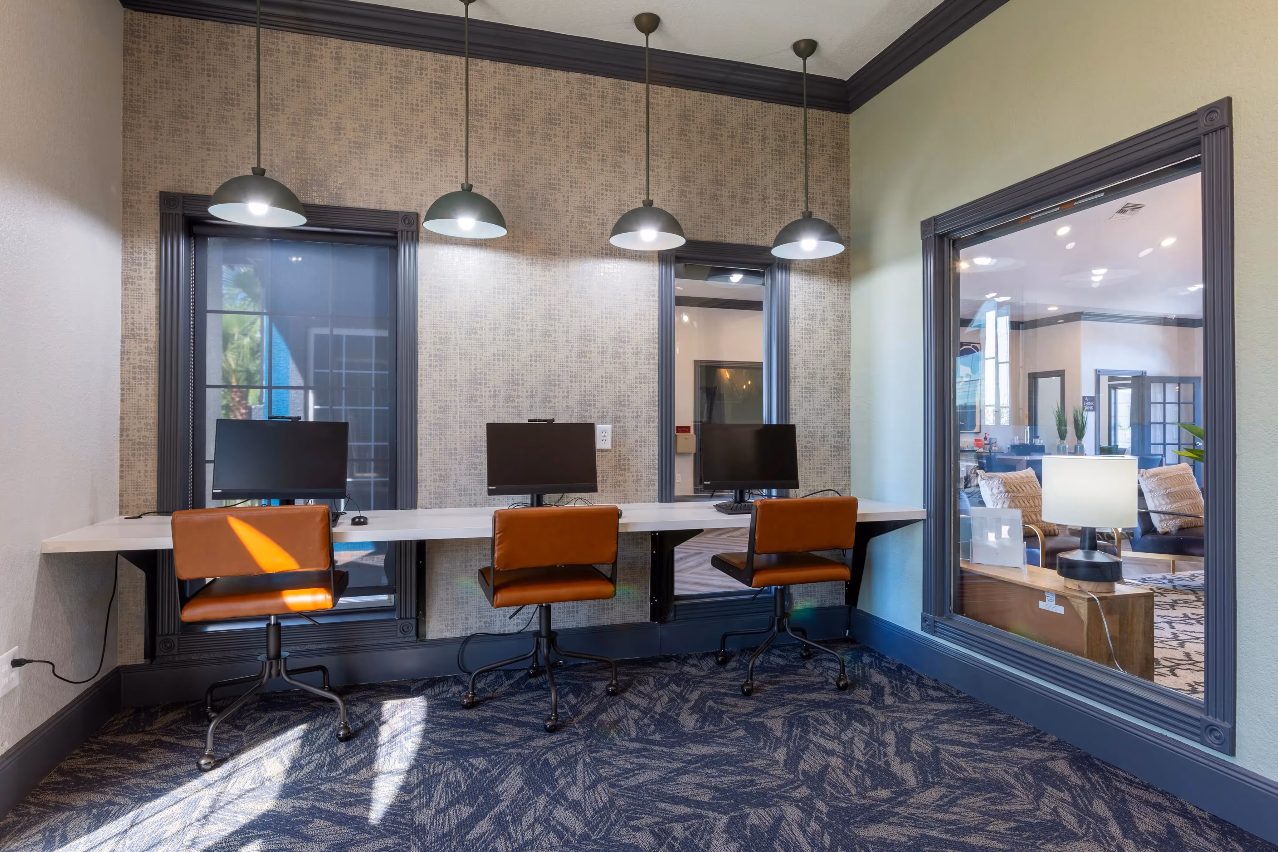 Resident business center with multiple computer stations and modern lighting, offering a productive environment at Ascension at Ironwood in Tucson, AZ.