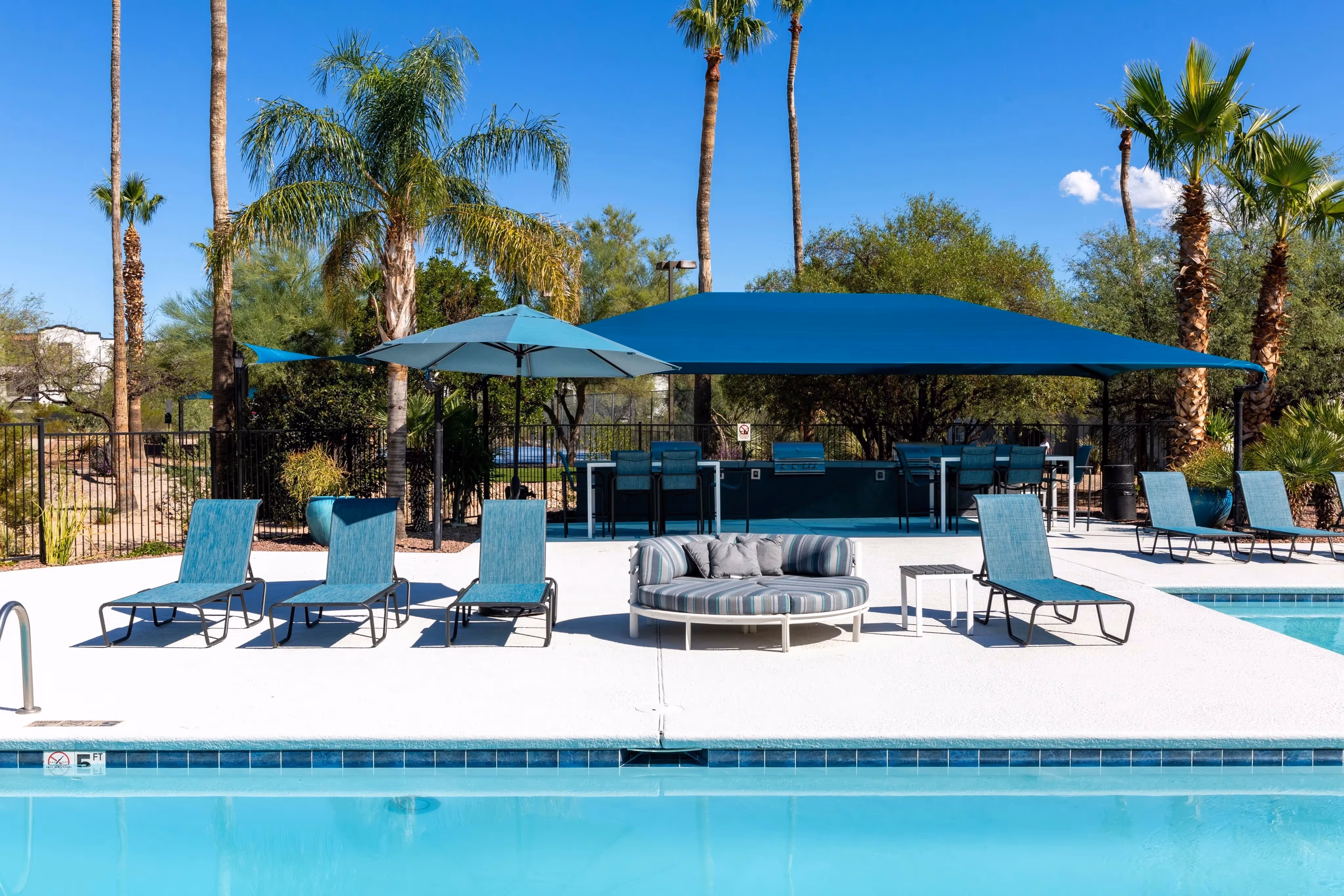 Outdoor grilling area and bar with shaded seating next to the swimming pool, a great social space at Ascension at Ironwood in Tucson, AZ.