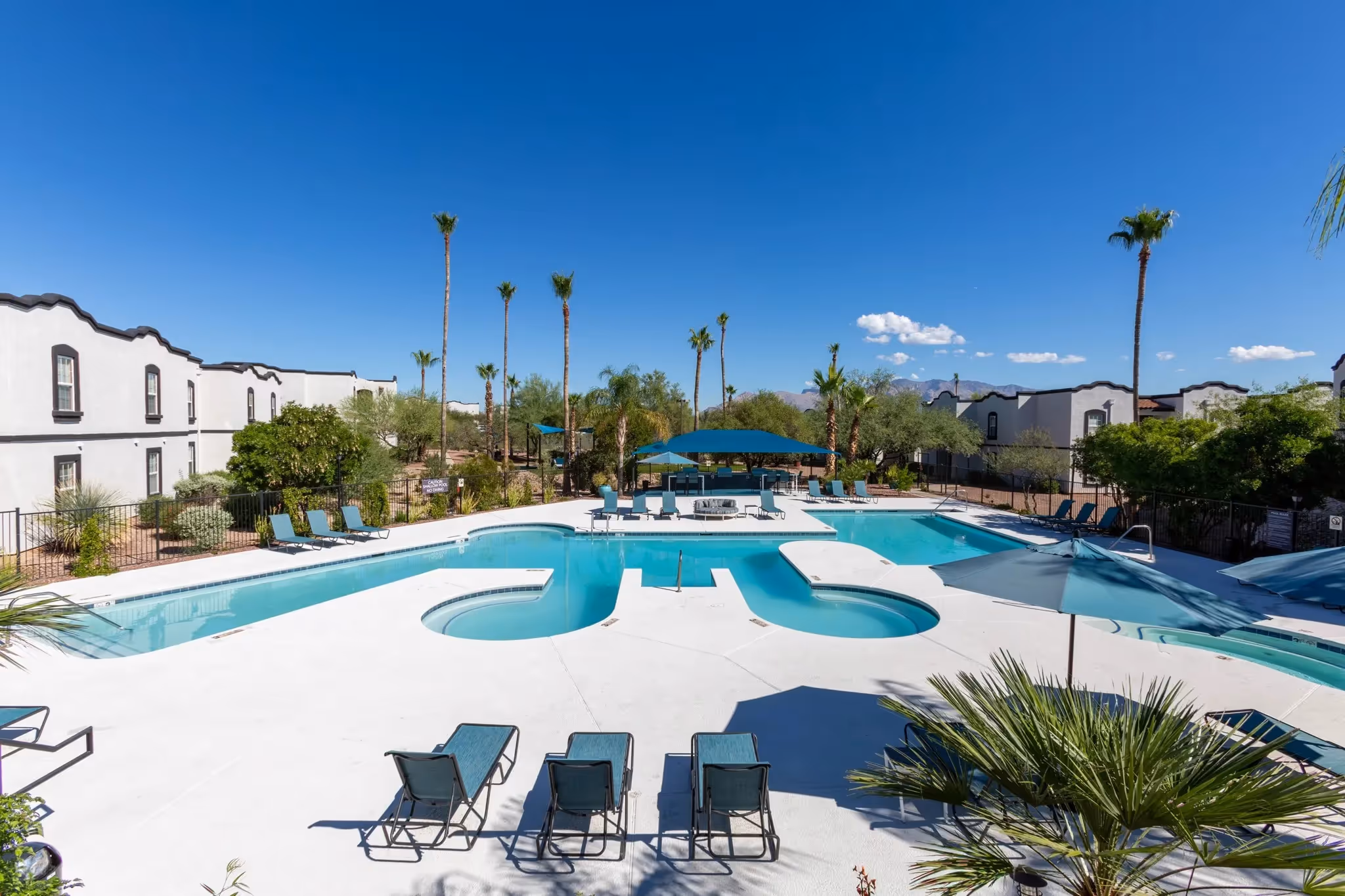 Large community swimming pool with lounge chairs and desert landscaping, offering a refreshing retreat at Ascension at Ironwood in Tucson, AZ.