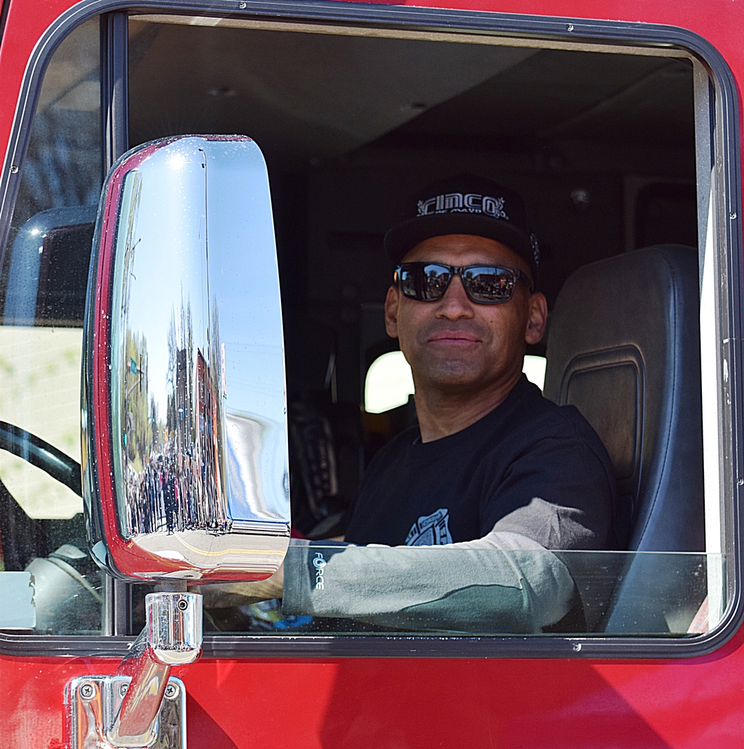 Saint Paul Firefighters Local 21 member in uniform sitting inside a fire truck cab.