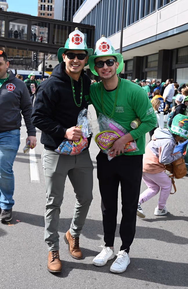 Saint Paul Firefighters Local 21 members wearing festive hats and beads during the St. Patrick’s Day celebration.