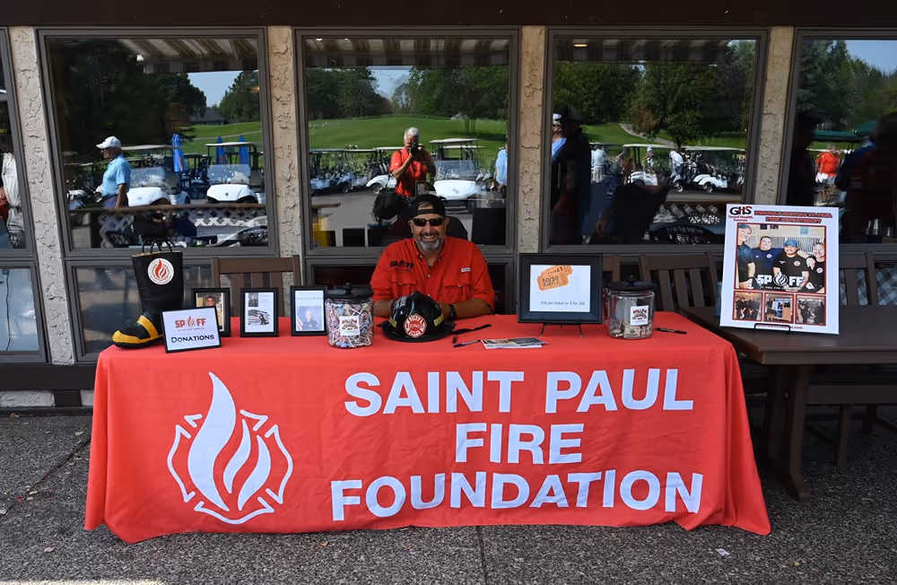 Saint Paul Fire Foundation table with donations and information displayed at a community event.