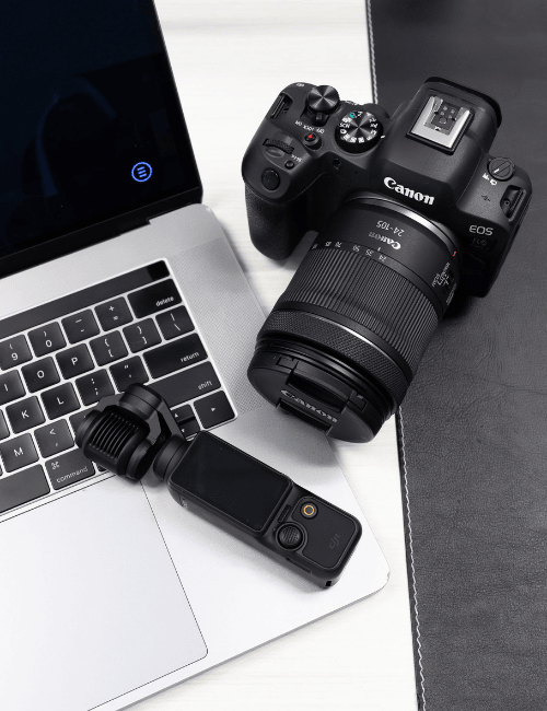 A Canon R6 Mark i and a DJI Osmo Pocket 7 sitting on a Mac Book laptop with The Ethos Team logo on the desktop screen.