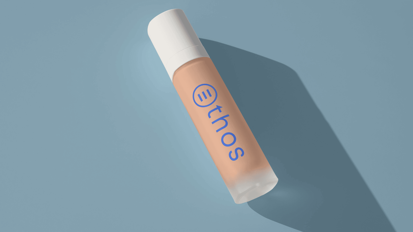 A concealer tube on a blue background with The Ethos Team logo on it as branding.