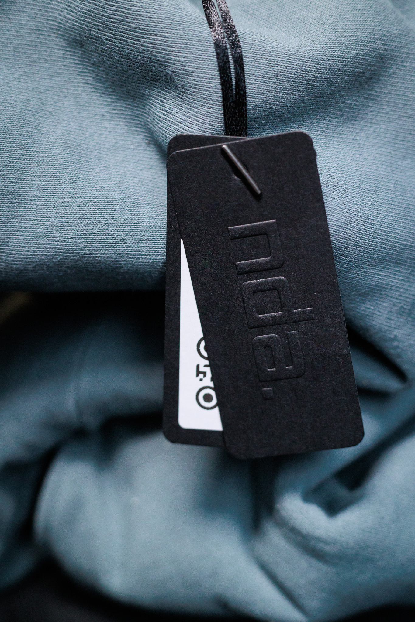 A close-up of a glacier blue sweatshirt and the clothing tag.