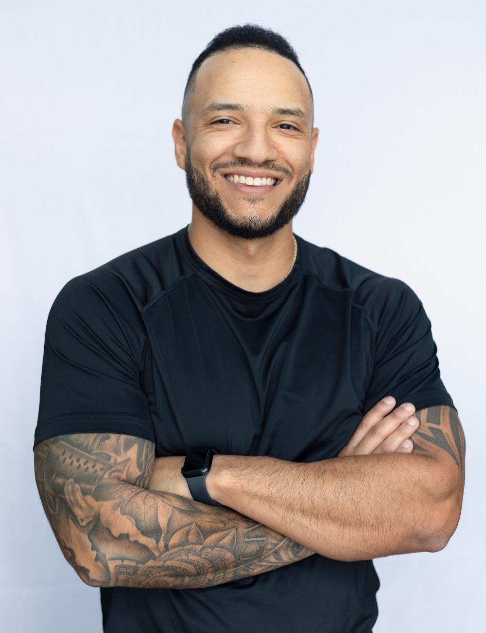 A man with his arms crossed posing for a picture.