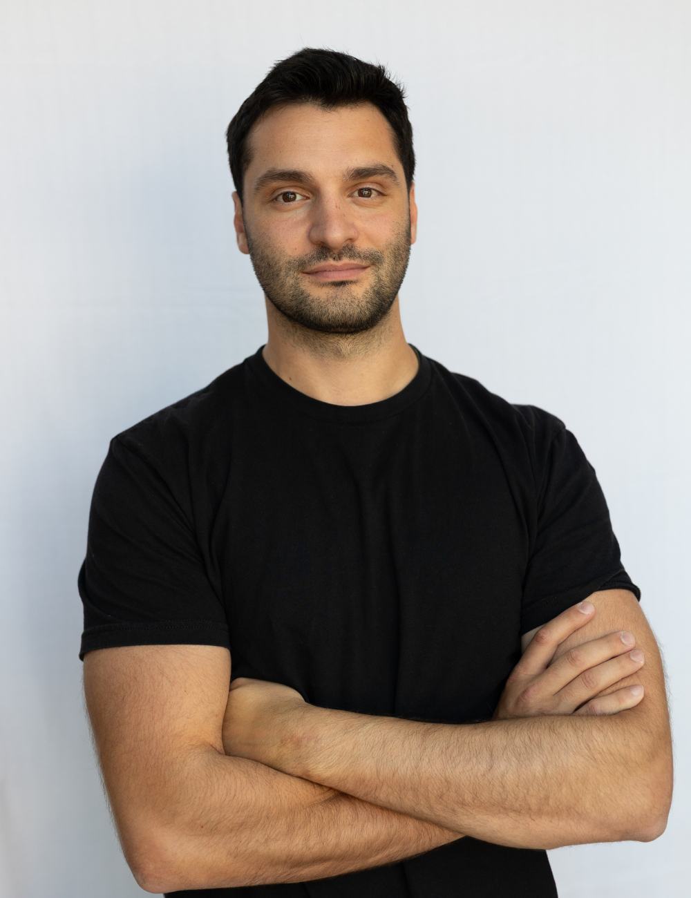 A man with his arms crossed posing for a picture.