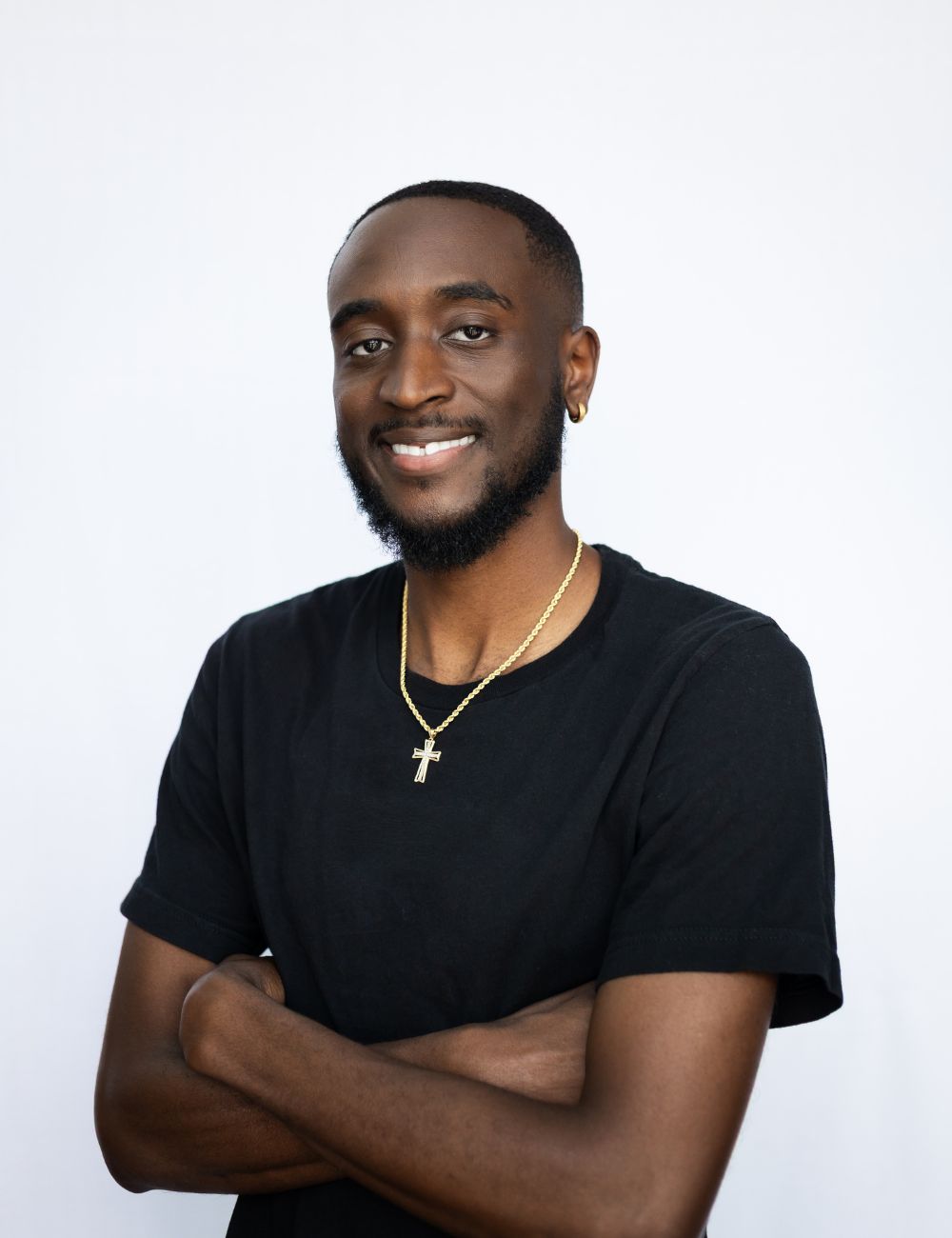 A man with his arms crossed smiling for a picture.