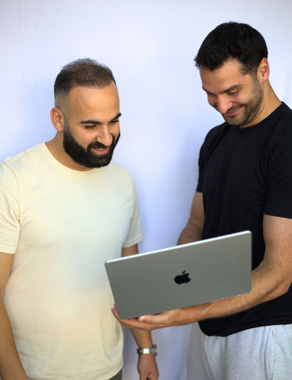 Two men looking at a laptop screen.