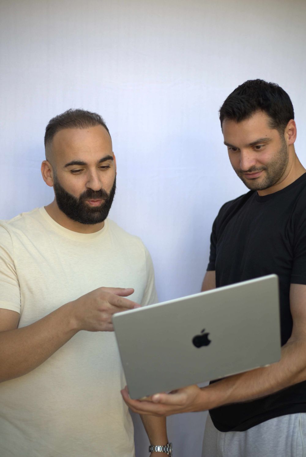 Two men looking at a really interesting laptop screen.