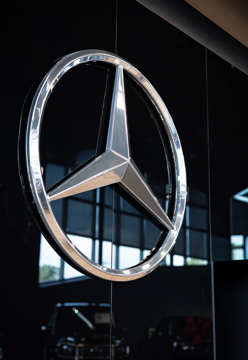 A Mercedes logo on the wall of the showroom.