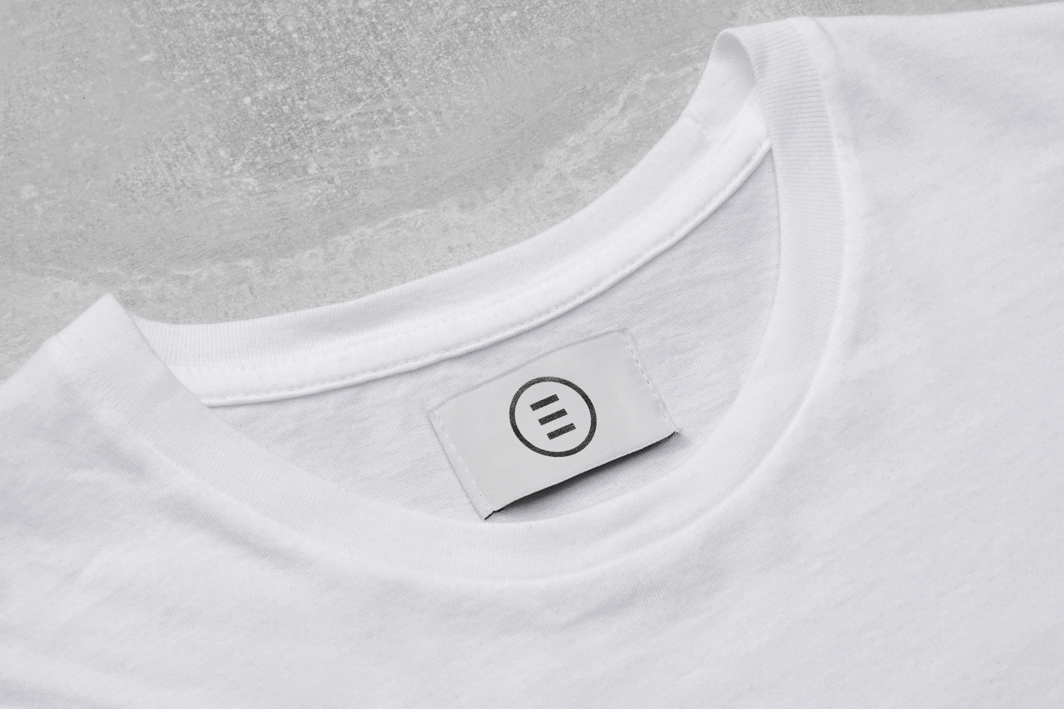 White t-shirt with small logo tag, close-up view