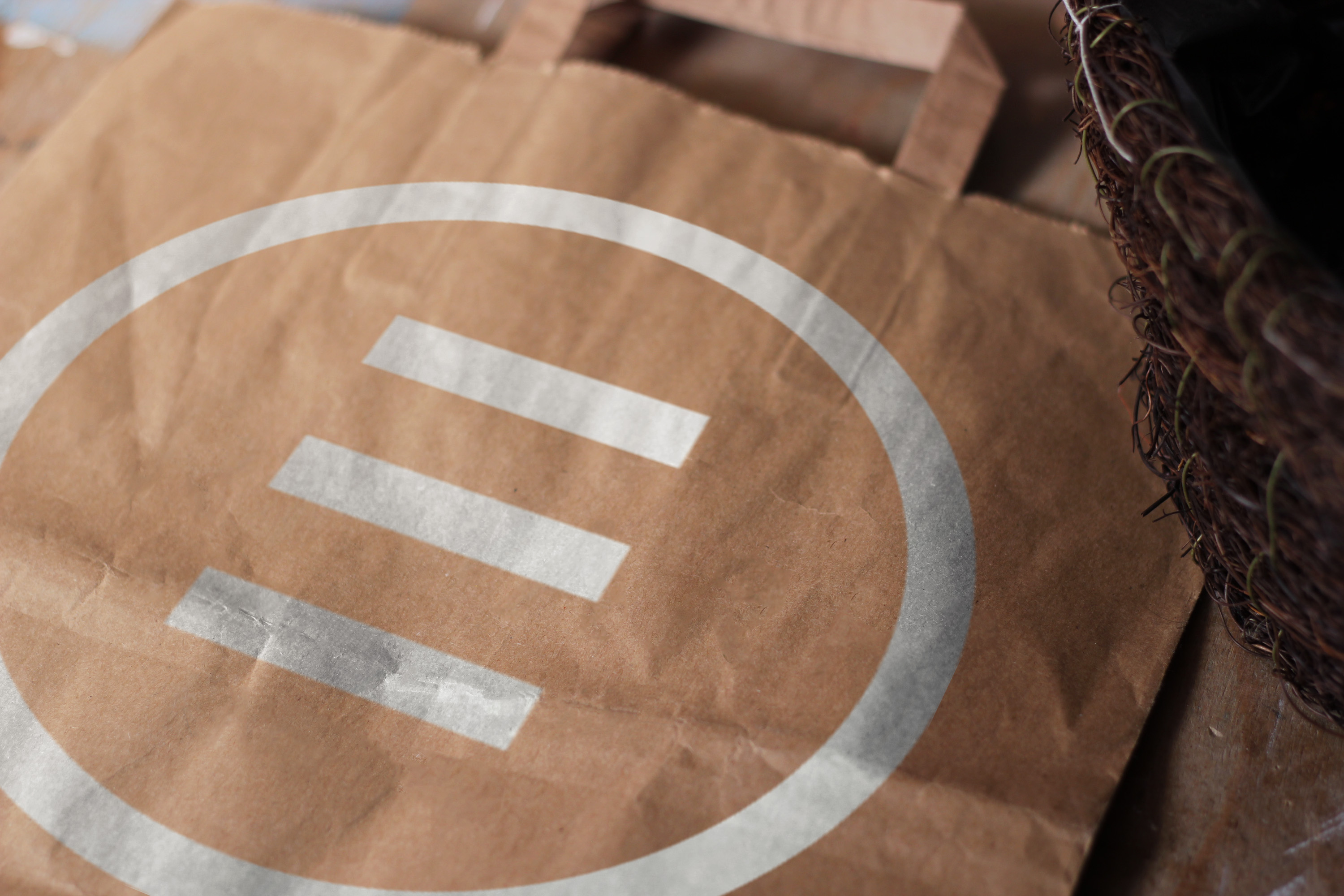 Brown paper bag with white circular logo close-up