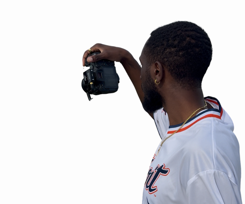 Person in white jersey holding digital camera from side view