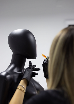 Injection artist performing medical injections on black mannequin head