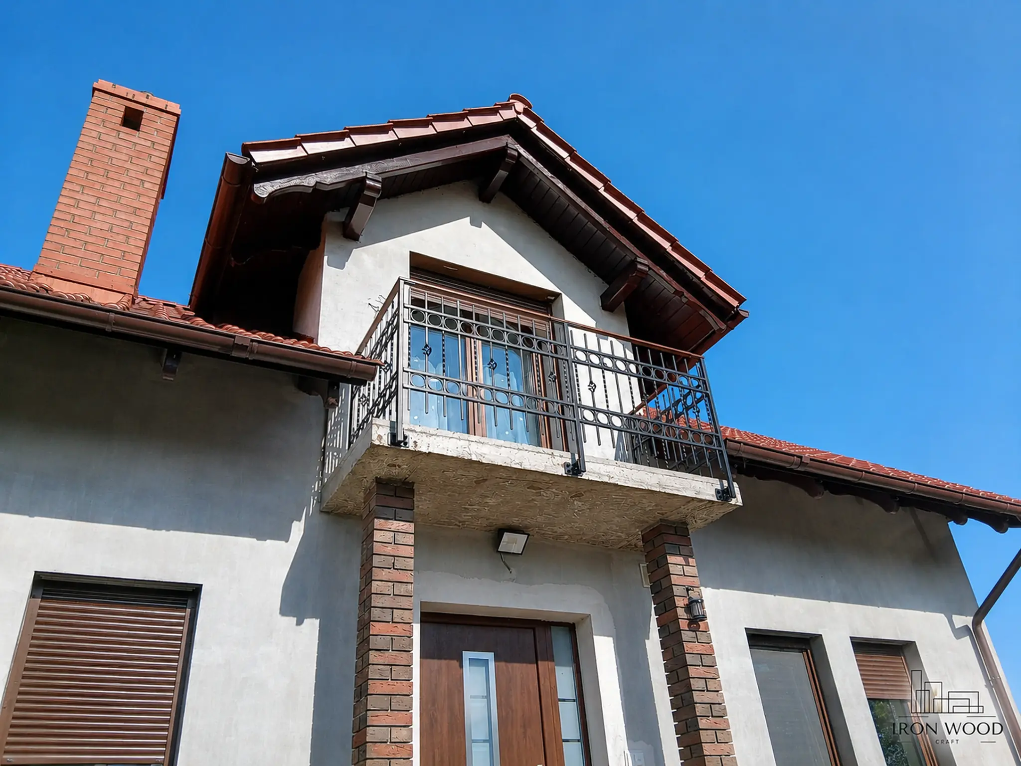 Nowoczesne schody z drewnianymi stopniami i czarną metalową balustradą w minimalistycznym wnętrzu z betonową ścianą i dużymi oknami.
