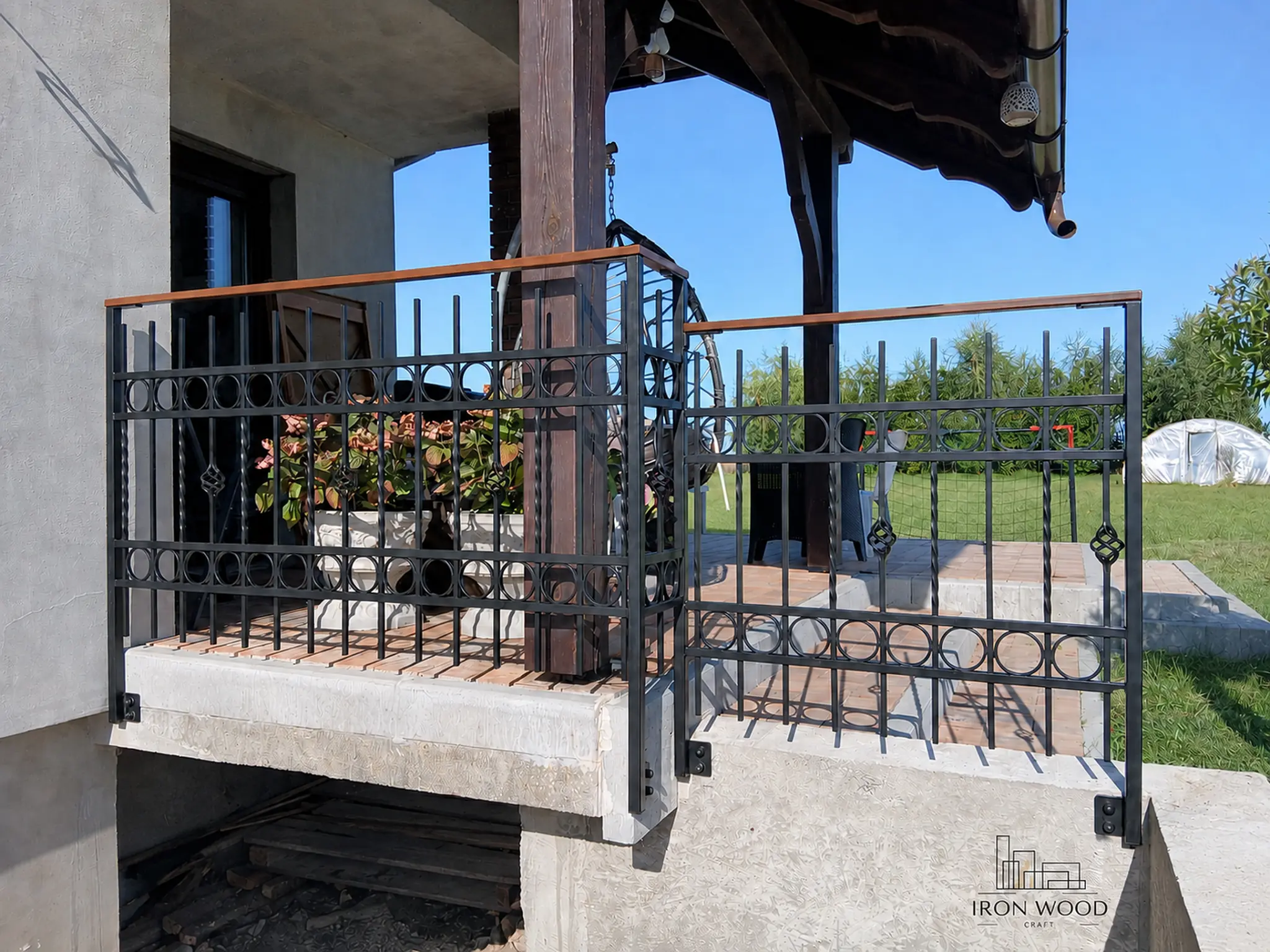 Nowoczesne schody z drewnianymi stopniami i czarną metalową balustradą w minimalistycznym wnętrzu z betonową ścianą i dużymi oknami.