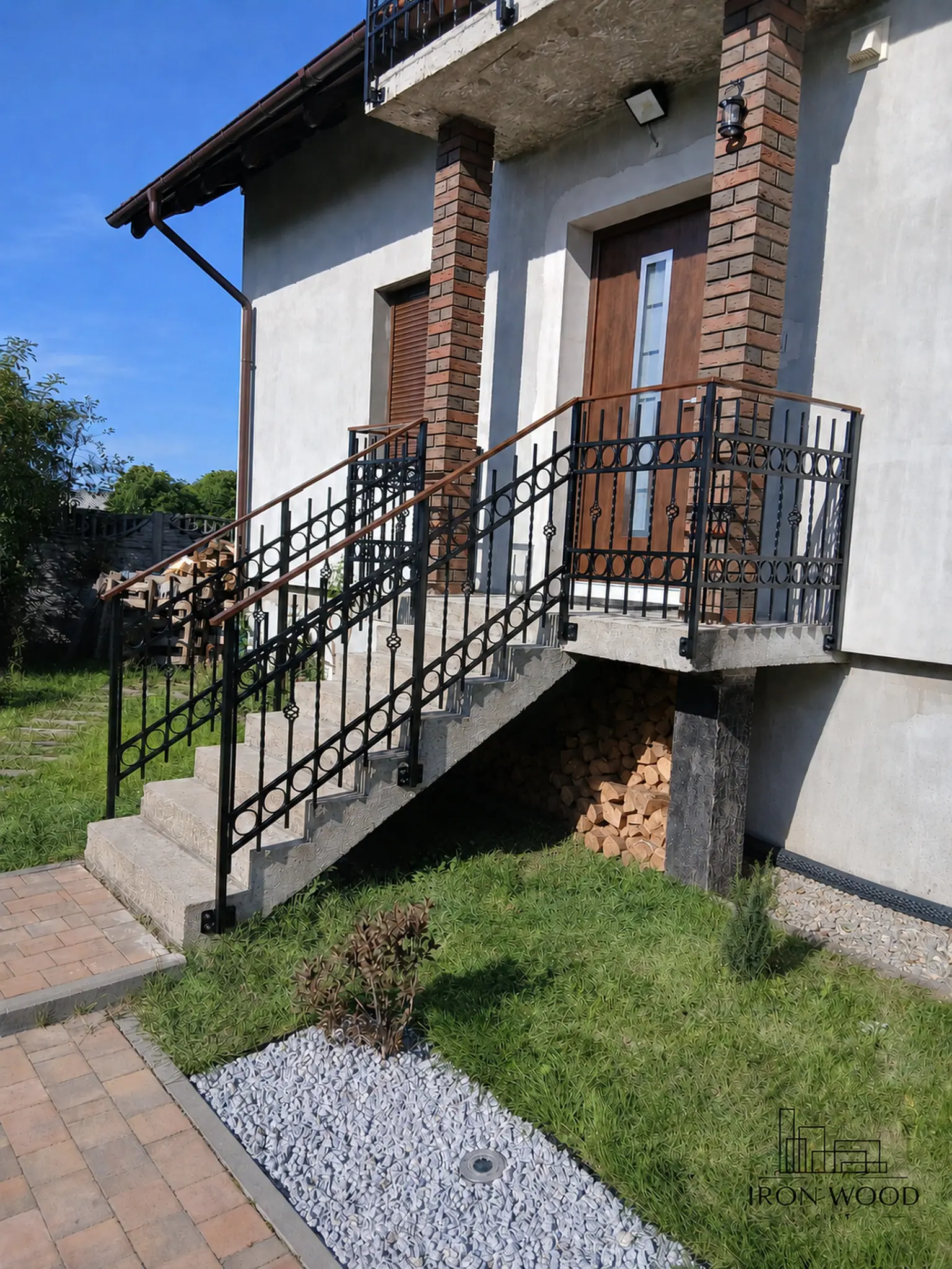 Nowoczesne schody z drewnianymi stopniami i czarną metalową balustradą w minimalistycznym wnętrzu z betonową ścianą i dużymi oknami.